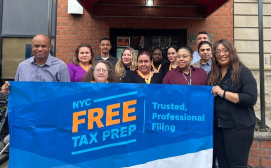 New York City tax team hold "free tax prep" sign.